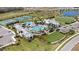 Aerial view of a community pool area with tennis courts, walking paths, and a lush green field at 2794 Butterfly Jasmine Trl, Sarasota, FL 34240