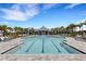 Community pool with lap lanes, poolside seating, and lush palm trees, creating a relaxing oasis at 2794 Butterfly Jasmine Trl, Sarasota, FL 34240