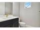 Chic powder room featuring a modern vanity with gold fixtures and a window for natural light at 2794 Butterfly Jasmine Trl, Sarasota, FL 34240