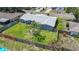 Aerial shot of the fenced backyard providing privacy, featuring lush green grass and mature landscaping at 2801 21St W Ave, Bradenton, FL 34205