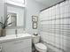 Bright bathroom featuring a shower with striped curtain and modern vanity with a stylish mirror at 2801 21St W Ave, Bradenton, FL 34205