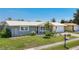 Charming single-story home with a well-manicured lawn, mature landscaping, and a two-car garage, set against a clear blue sky at 2801 21St W Ave, Bradenton, FL 34205
