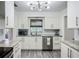 Updated kitchen featuring white cabinets, stainless steel appliances, and modern lighting at 2801 21St W Ave, Bradenton, FL 34205