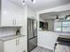Modern kitchen with white cabinets, stainless steel refrigerator, and an open view to living area at 2801 21St W Ave, Bradenton, FL 34205