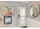 Entryway of home with a white door, wall art, mirror, and wainscoting at 33 S Gulfstream Ave # 306, Sarasota, FL 34236