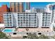 Apartment complex with a pool and an entrance with a bricked drive and mature landscaping at 33 S Gulfstream Ave # 306, Sarasota, FL 34236