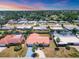 Neighborhood aerial view with a red tiled house, landscaped yards, and mature palm trees at 3426 Brookline Dr, Sarasota, FL 34239