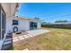 Spacious backyard features a sliding glass door, tile patio, and well-maintained lawn under a clear blue sky at 3426 Brookline Dr, Sarasota, FL 34239