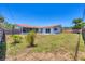 The fenced backyard features a well-maintained lawn, small trees, and a view of the house and patio at 3426 Brookline Dr, Sarasota, FL 34239