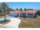 Charming single-story home with a red tile roof and a curved driveway, surrounded by palm trees at 3426 Brookline Dr, Sarasota, FL 34239
