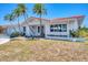 Inviting single-story home with a red tile roof, lush landscaping, and a well-manicured front yard at 3426 Brookline Dr, Sarasota, FL 34239