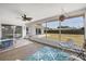 Cozy sunroom with a ceiling fan, seating, and a view of the landscaped backyard and tiled patio at 3426 Brookline Dr, Sarasota, FL 34239