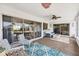 This sunroom offers a relaxing space with cushioned seating, a ceiling fan, and views of the backyard at 3426 Brookline Dr, Sarasota, FL 34239