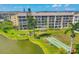 Aerial view of condo community overlooking a tranquil lake, shuffleboard, and manicured green spaces at 3521 Lake Bayshore Dr # 3521, Bradenton, FL 34205