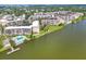 Overhead view featuring a condo community with a pool, pier, mature trees, and views of the lake at 3521 Lake Bayshore Dr # 3521, Bradenton, FL 34205