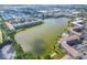 Aerial view showcasing the condo community, its buildings, and a serene lake at 3521 Lake Bayshore Dr # 3521, Bradenton, FL 34205