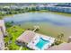 Stunning aerial view showcasing a lakefront community pool, a covered pier and lush landscaping at 3521 Lake Bayshore Dr # 3521, Bradenton, FL 34205