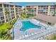 A perfect aerial perspective of a community pool with many lounge chairs and umbrellas for a relaxing atmosphere at 3521 Lake Bayshore Dr # 3521, Bradenton, FL 34205