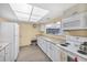 Shared kitchen featuring white appliances, cabinets, and a large window for views into the library at 3521 Lake Bayshore Dr # 3521, Bradenton, FL 34205