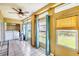 Enclosed Lanai featuring tile flooring, ceiling fan, and views of backyard and laundry area at 3521 Lake Bayshore Dr # 3521, Bradenton, FL 34205