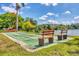 Outdoor shuffleboard court with benches, nearby lake, and landscaping at 3521 Lake Bayshore Dr # 3521, Bradenton, FL 34205
