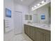 Bathroom featuring double sinks, white marble floors, and gray cabinets at 3631 Shimmering Oaks Dr, Parrish, FL 34219