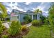 Inviting single-story home with tropical landscaping, green lawn, and attached two-car garage at 3631 Shimmering Oaks Dr, Parrish, FL 34219