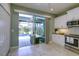 Bright kitchen features white cabinets, stainless steel appliances, and sliding doors to a screened pool and patio at 3631 Shimmering Oaks Dr, Parrish, FL 34219