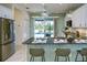Stylish kitchen with a breakfast bar, stainless steel appliances, and sliding glass doors to a screened in pool at 3631 Shimmering Oaks Dr, Parrish, FL 34219