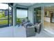 Screened patio with wicker furniture, a view of the garden, and a sliding glass door to the kitchen at 3631 Shimmering Oaks Dr, Parrish, FL 34219