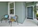 Charming front porch with seating area and a colorful front door at 3631 Shimmering Oaks Dr, Parrish, FL 34219