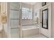 This bathroom features tile flooring, a shower, and a soaking tub with a glass block window at 3804 Amapola Ln, Sarasota, FL 34238