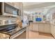 Open kitchen flows into living area with breakfast bar and stainless steel appliances at 3804 Amapola Ln, Sarasota, FL 34238