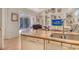 Kitchen island featuring granite countertop and stainless steel sink overlooking the living area and lanai at 3804 Amapola Ln, Sarasota, FL 34238