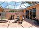 This outdoor patio features brick flooring, a dining table, a chaise lounge, and a screen enclosure at 3804 Amapola Ln, Sarasota, FL 34238