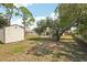 Spacious backyard featuring shed, landscaping, and mature shade trees at 3881 Holin Ln, North Port, FL 34287