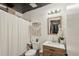 Cozy bathroom with shower, wood-look vanity, framed mirror and decorative accents at 3881 Holin Ln, North Port, FL 34287
