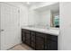 Well-lit bathroom featuring a double sink vanity with a large mirror and white doors at 4091 Dull St, North Port, FL 34286