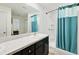 Bathroom with a modern vanity, bright lighting, and shower with blue curtain at 4091 Dull St, North Port, FL 34286
