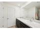 Bright bathroom with double sinks, a large mirror, and white doors at 4091 Dull St, North Port, FL 34286