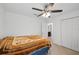 Cozy main bedroom featuring tile floors, a ceiling fan, and an en-suite bathroom at 4091 Dull St, North Port, FL 34286