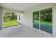 Covered patio with sliding glass doors that lead to the lush green backyard at 4091 Dull St, North Port, FL 34286