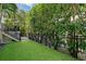 Well-maintained backyard with artificial turf, wrought iron fencing, and lush greenery for privacy at 4108 Roberts Point Rd, Sarasota, FL 34242