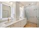 Bright bathroom showcases a glass shower and double sinks with white marble countertops at 4108 Roberts Point Rd, Sarasota, FL 34242