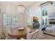 Elegant dining area with a chandelier, large windows, and seamless flow into the living space at 4108 Roberts Point Rd, Sarasota, FL 34242