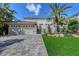Charming two-story home with a three-car garage, tiled roof, and tropical landscaping at 4108 Roberts Point Rd, Sarasota, FL 34242