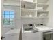Convenient laundry room with modern washer and dryer and ample storage shelves at 4108 Roberts Point Rd, Sarasota, FL 34242