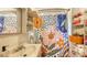 Bathroom features colorful shower curtain and shelves for storage at 4122 Old Bradenton Rd, Sarasota, FL 34234
