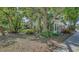 An older two-story home nestled among trees and shrubs, complemented by a cozy yard and a sidewalk at 4122 Old Bradenton Rd, Sarasota, FL 34234