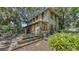 Two-story home featuring a wooden deck, mature trees, and quaint architectural details at 4122 Old Bradenton Rd, Sarasota, FL 34234